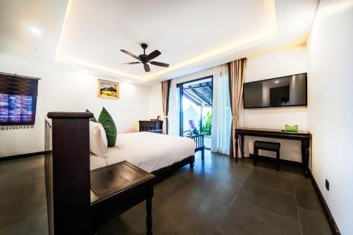 琅勃拉邦Manyo Hotel and Resort的酒店客房,配有床和电视