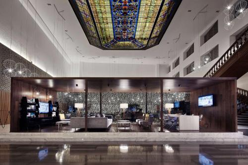 蒙特雷Wyndham Monterrey Ambassador Centro的大堂设有大型彩色玻璃天花板和带沙发的房间