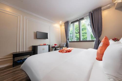 河内Omina Hanoi Hotel & Travel的卧室设有一张白色大床和一扇窗户。