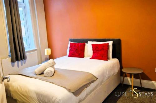Old WalkerLuke Stays - Welbeck Road的一间卧室配有红色枕头的床