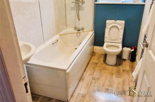 Old WalkerLuke Stays - Welbeck Road的浴室配有卫生间、浴缸和水槽。