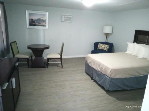 桑福德Homes -N - Courts的酒店客房带一张床、一张桌子和椅子