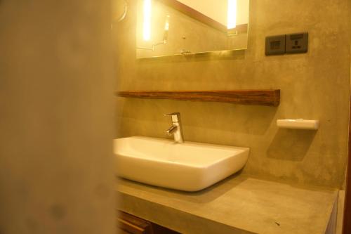 本托塔Red Coconut Villa的浴室设有白色水槽和镜子