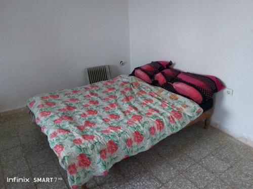 TipazaJerry's hole的一间卧室配有一张带花卉棉被的床
