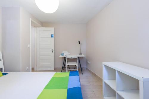 波尔图Relógio Guest House的白色的客房配有一张床和一张书桌