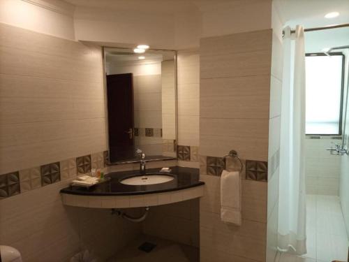 拉合尔Falettis Express DHA的一间带水槽和镜子的浴室
