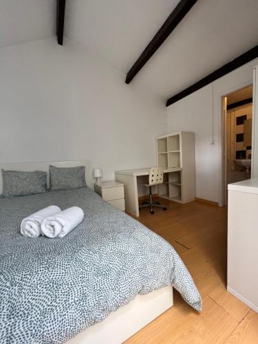 波尔图Relógio Guest House的一间卧室配有一张床,上面有两条毛巾