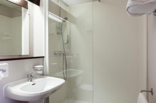 梅里尼亚克The Originals City, Hôtel du Phare, Bordeaux Mérignac (Inter-Hotel)的白色的浴室设有水槽和淋浴。
