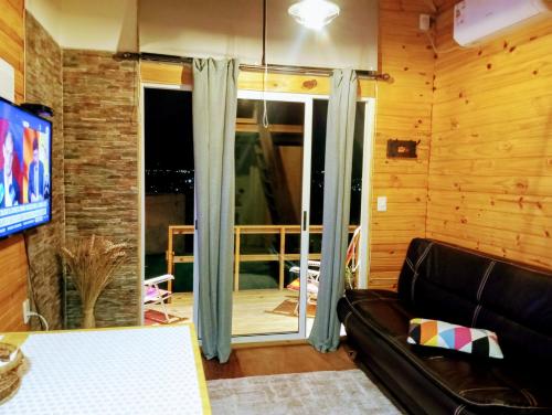 皮里亚波利斯Hermosa cabaña con excelente vista panorámica的带沙发和滑动玻璃门的客厅
