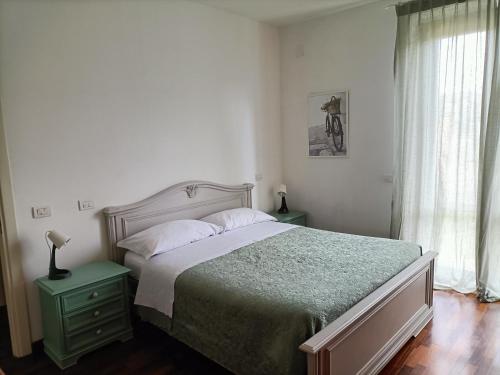 福利尼奥Casa Emilia - Appartamento per vacanze - Foligno的一间卧室配有一张带绿色床头柜和窗户的床。