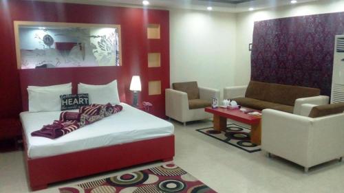 木尔坦Five Mounts Hotel And Restaurant的一间卧室配有一张床、两把椅子和一张沙发