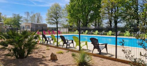 Ambérieux-en-DombesL'Oasis des Dombes的一组椅子坐在游泳池旁