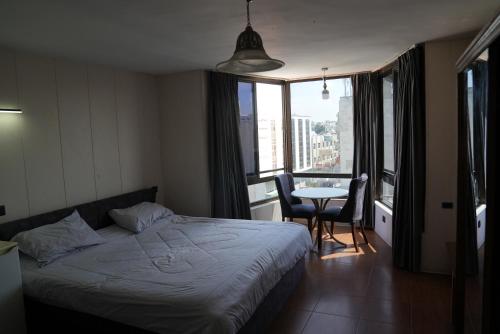 伊尔比德Omayah hotel irbid的一间卧室配有一张床和一张桌子及椅子