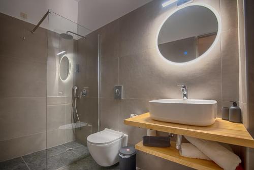 穆兹罗斯To Kyma的一间带水槽、卫生间和镜子的浴室