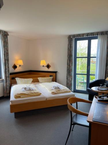 沙普罗德Hotel Zur alten Schmiede的卧室配有床、椅子和窗户。
