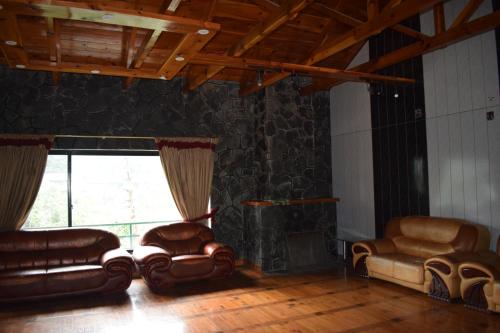 Nathia GaliRoyal House 2的客厅配有皮革家具和大窗户