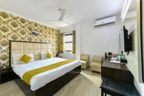 阿格拉Hotel First by Goyal Hoteliers的酒店客房设有一张大床和一张书桌。