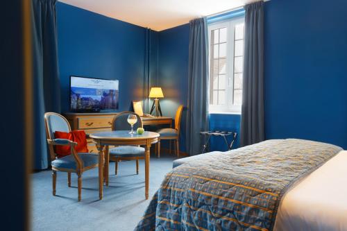 科尔马Logis Hôtel Beauséjour Colmar的酒店客房带一张床、一张桌子和椅子