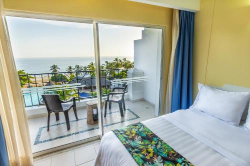 圣玛尔塔GHL Relax Hotel Costa Azul的一间卧室设有一张床和一个海景阳台