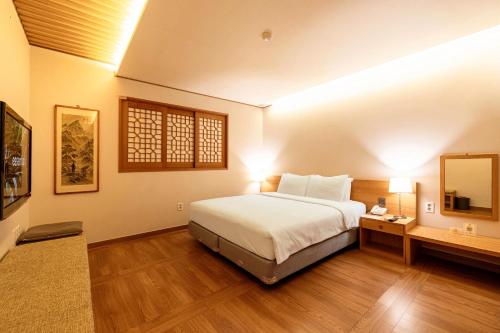 首尔首尔仁寺洞上宾酒店的一间卧室配有一张大床和镜子