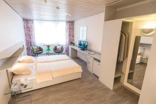 拉登堡Hotel Cronberger Hof的一间卧室配有一张床、一张书桌和一台电视