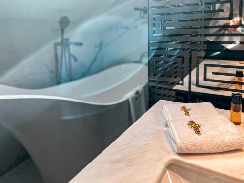马拉加Anahita Boutique Hotel的带浴缸、毛巾和盥洗盆的浴室