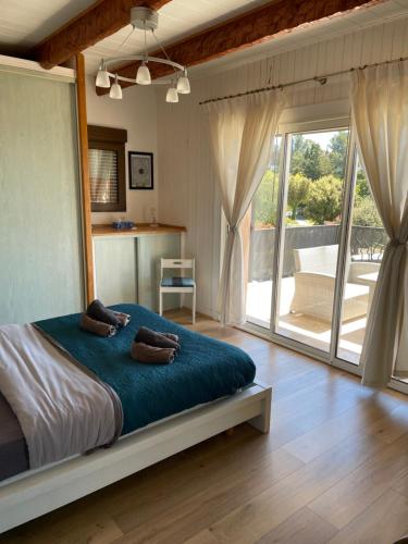 勒·雷约尔·卡纳德尔·苏尔蓝色海湾公寓的一间卧室设有一张大床和一个大型滑动玻璃门