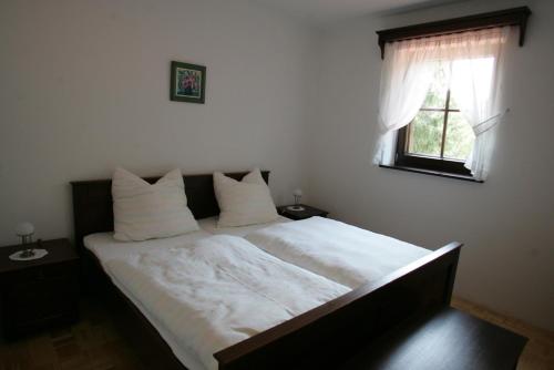柳托梅尔Farm Stay Frank Ozmec Wine and Glamping estate的一间卧室配有一张带白色床单的床和一扇窗户。