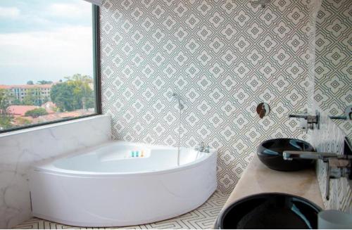 KisubiLake view property的带窗户的浴室内的白色浴缸
