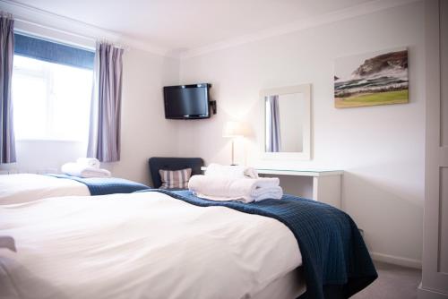 帕兹托特莱沃斯高尔夫乡村俱乐部的酒店客房设有两张床和一台墙上的电视。