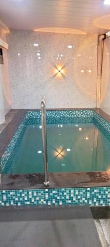达曼Dev Kirtan Villa的一座房子内的游泳池,铺有瓷砖地板
