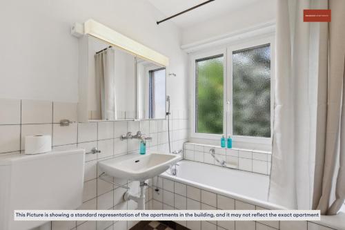 苏黎世15-Min to Zurich Center: Cozy Apartment的白色的浴室设有水槽、浴缸和窗户。