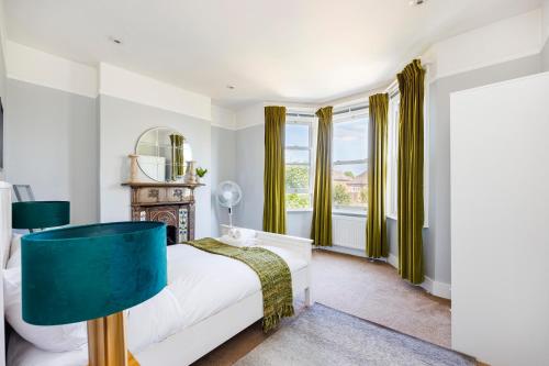 伦敦6 Bedroom House by AV Stays Acton Sleeps 11 Free Parking的一间卧室配有一张床和镜子