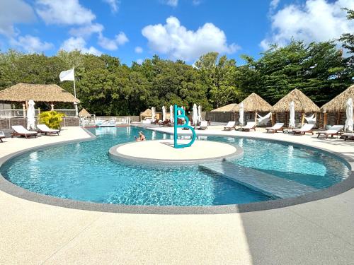 大博格La Kawanaise Blue Lagon的度假村的游泳池,配有椅子和遮阳伞