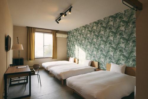 IkataHanaguri-しまなみ海道スマート旅館的酒店客房内的一排床位