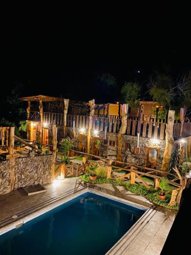 维库尼亚Cabañas Rusticas Olimpus del Elqui的夜间在围栏前的游泳池