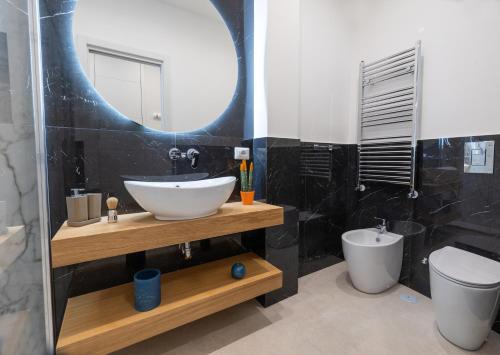 那不勒斯Napoli City Center - Appartamenti e Camere的一间带水槽、卫生间和镜子的浴室