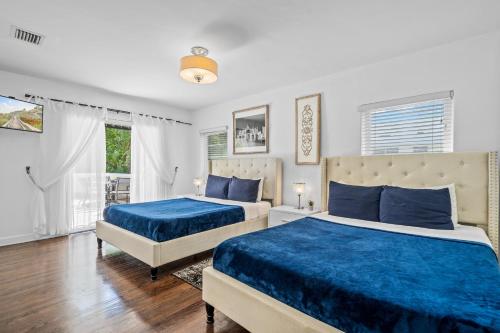 迈阿密海滩Villa Venezia BB full house up to 12 guests的卧室设有两张床铺,配有蓝色床单