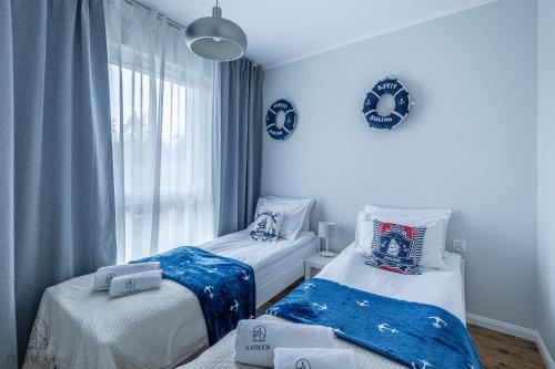 詹塔尔Flatbook Apartamenty - Jantar Resort的一间卧室设有两张床和窗户。