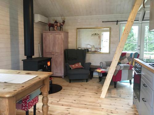 TingsrydPippis Cottage的厨房和带燃木炉的客厅