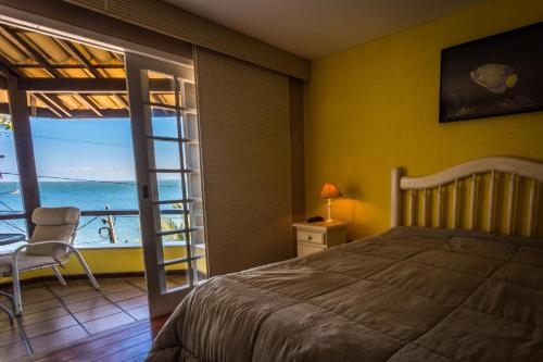 圣佩德罗-达阿尔德亚Pousada Pontal da Praia的一间卧室配有一张床,享有海景