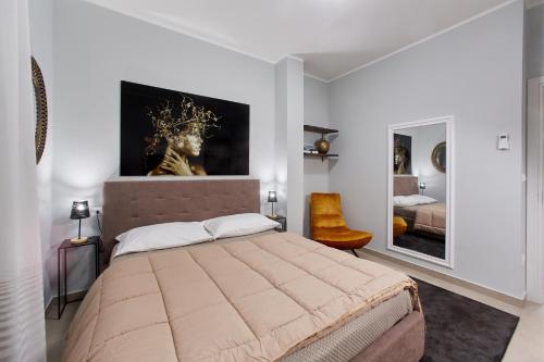 雷焦卡拉布里亚Showroom Luxury B&B的卧室配有一张大床,墙上挂有绘画作品