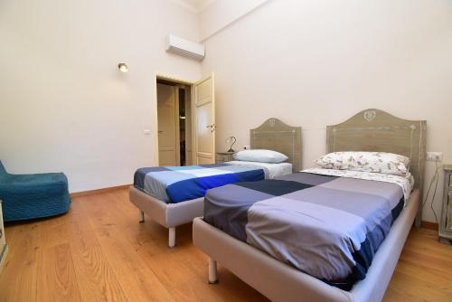 彼得拉桑塔Appartamento a 150M dal Duomo的一间卧室配有两张床和一张蓝色椅子