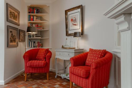 阿克斯姆Haus Jöljarm Hüs的客厅配有两张红色椅子和一张桌子