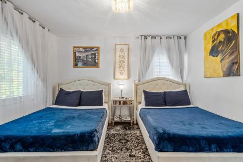 迈阿密海滩villa venezia bb的卧室设有两张床铺,配有蓝色床单