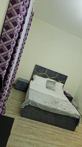 迪拜Luxury Rooms的一间卧室配有一张带紫色窗帘的床