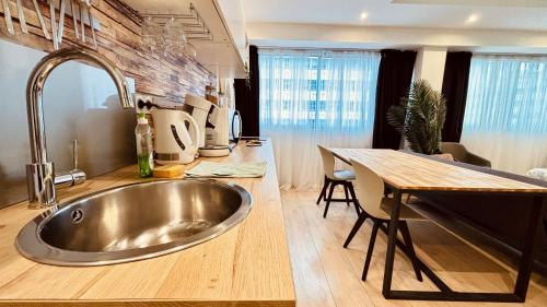 里昂☆Loft 35m2 Lyon 6 Ménage inclus/pas de check out☆的厨房配有不锈钢水槽和桌子