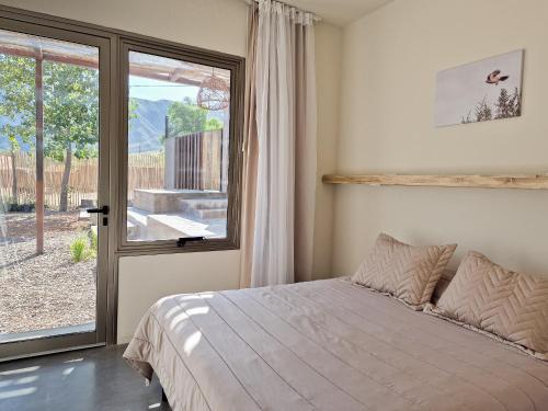 卢汉德库约Miramonte Posada的一间卧室设有一张床和一个大窗户