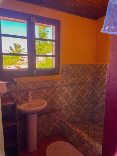 陶拉纳鲁Le Famanta - Hotel & Restaurant的一间带水槽和卫生间的浴室以及窗户。