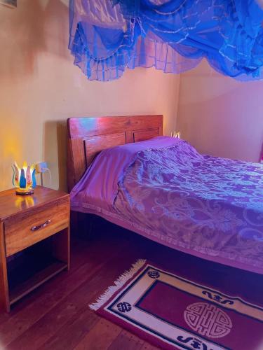 陶拉纳鲁Le Famanta - Hotel & Restaurant的一间卧室配有一张床、一张桌子和一张地毯。